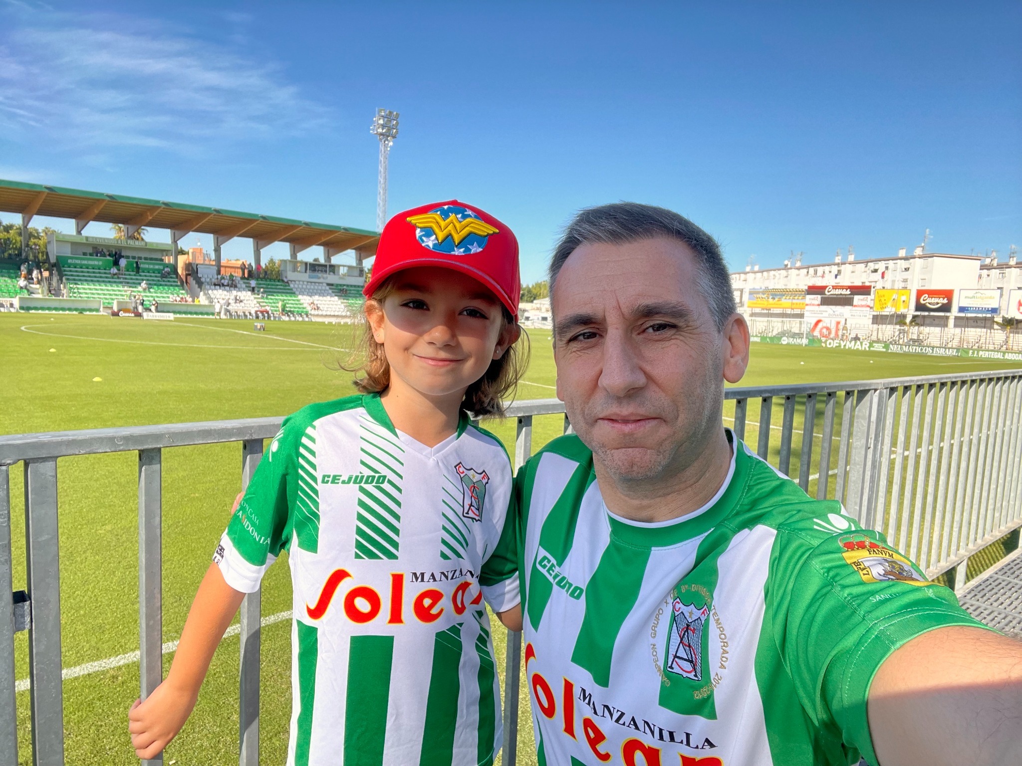 Rafa con una de sus hijas en el Estadio El Palmar, con camisetas del Atlético Sanluqueño CF