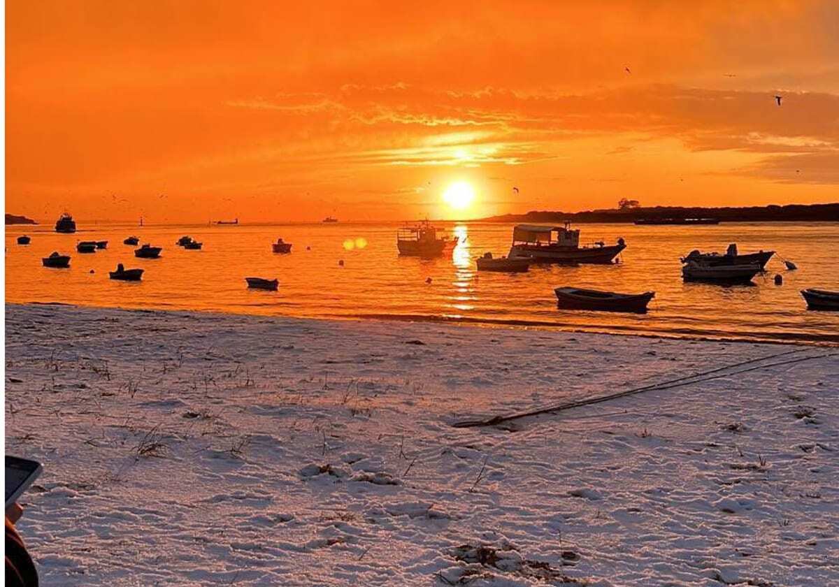 Embarcaciones frente a Sanlúcar durante un atardecer anaranjado